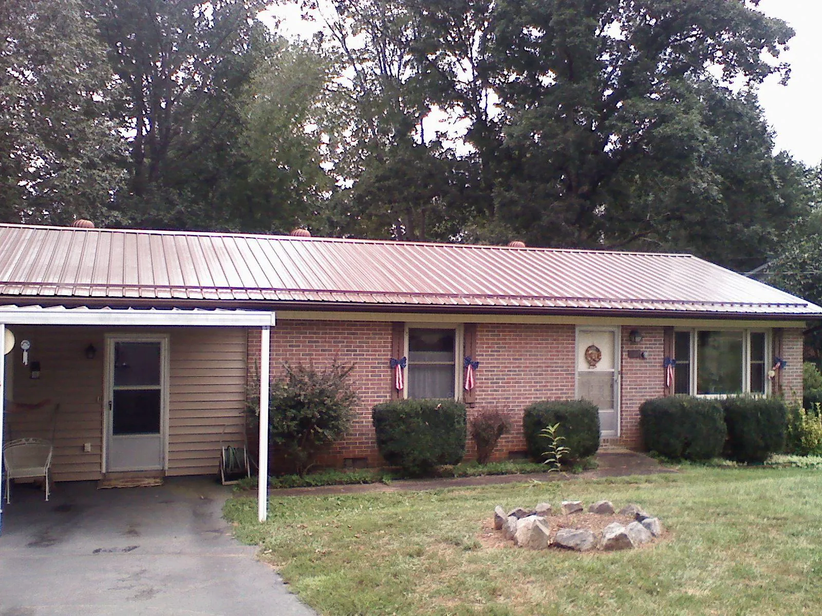 Bronze metal roof and carport on a brick ranch home — Roof Repair work by our crew in Holton