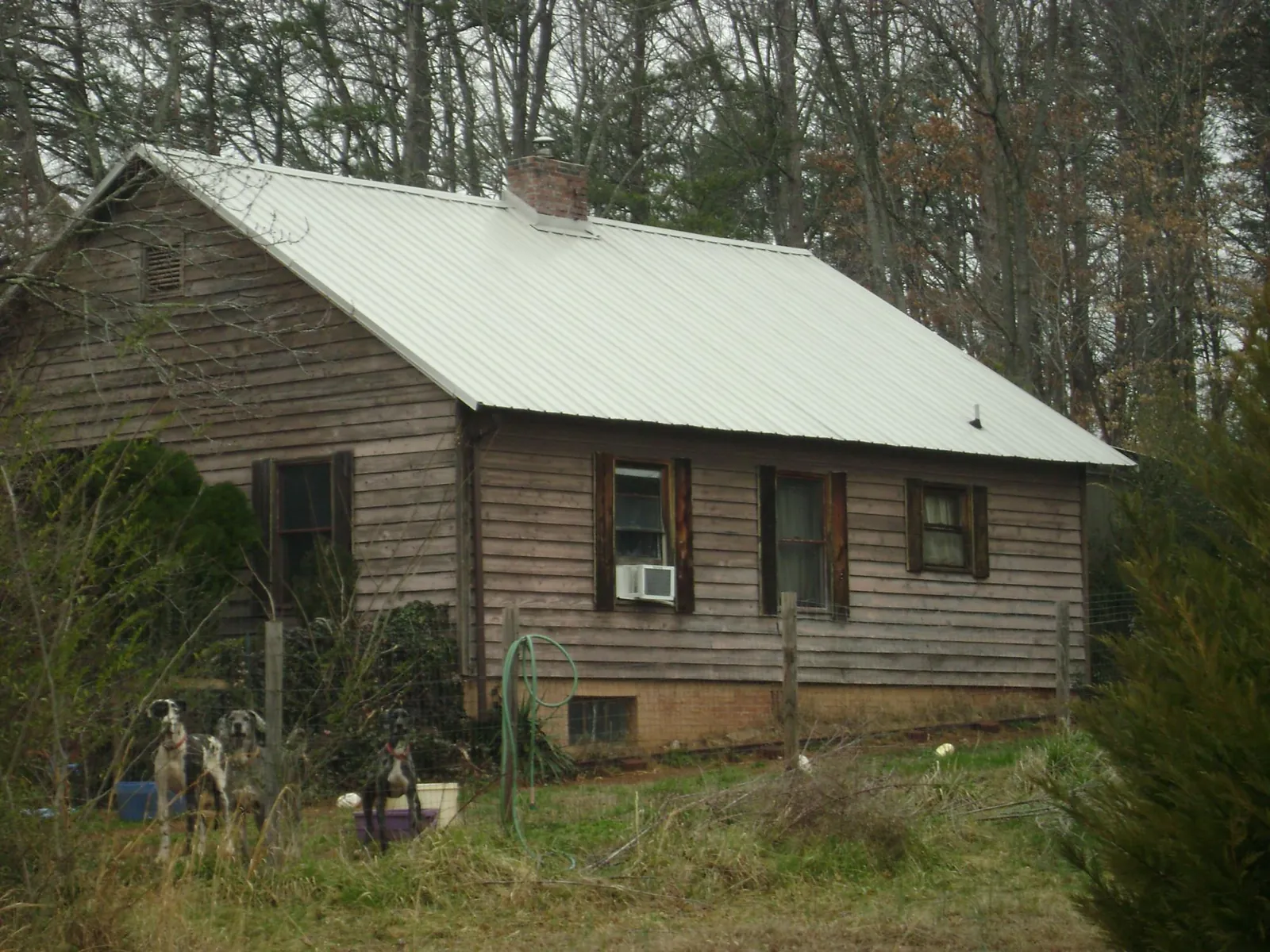 White metal roof on an old wood sided farmhouse, from a Metal Roof Installation job in Holton